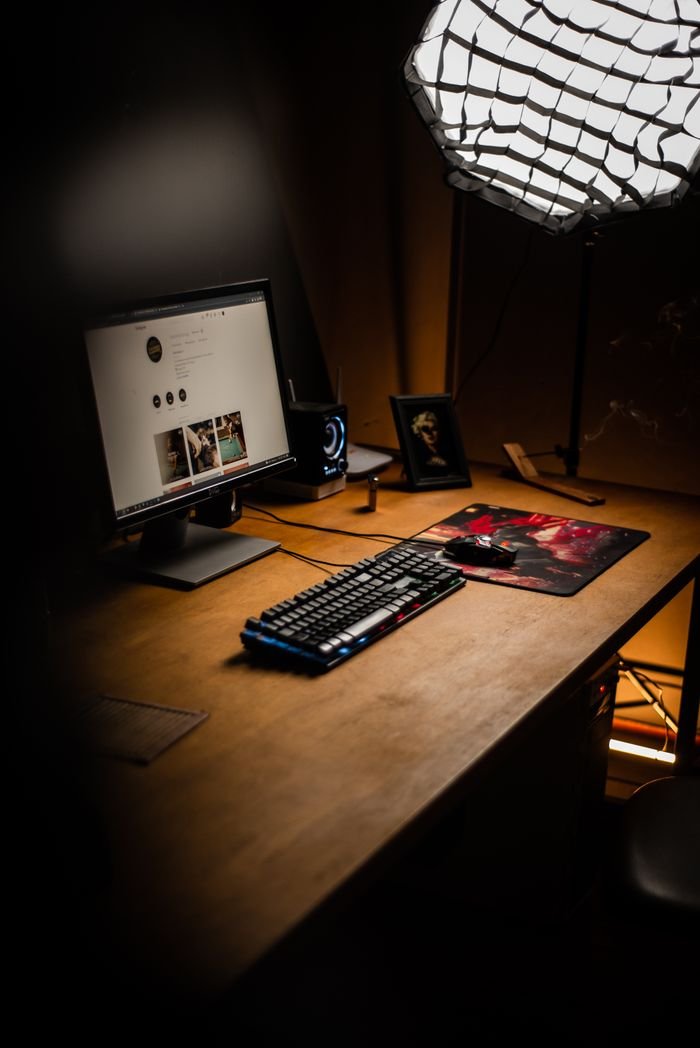 Inicio A minimalist desk setup featuring a monitor, keyboard, and mouse, under soft lighting, ideal for productivity.